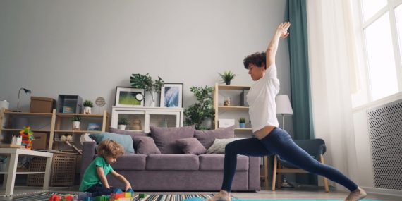 a woman and a child doing yoga in a living room